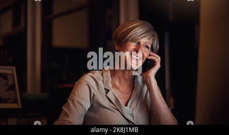 Im happy to report that the project is complete. an attractive mature businesswoman working on her computer and making a phonecall in the office late Stock Photo