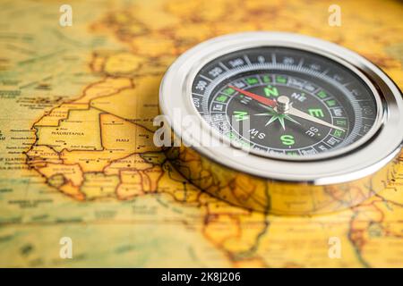 Bangkok, Thailand - January 20, 2022 Compass for navigation on vintage old antique world map background to travel, geography, tourism and exploration Stock Photo