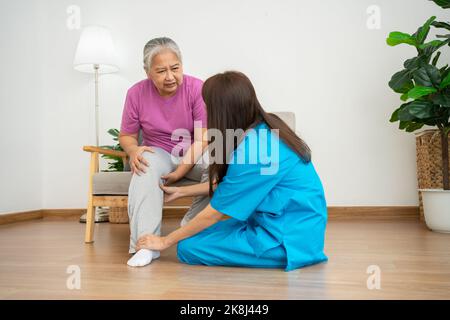physiotherapist doctor or caregiver helping senior older woman stretching his hamstring and doing thigh or leg rehabilitation in exercise room, Osteoa Stock Photo