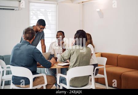 We get along so well. a diverse group of businesspeople having a meeting in the office together during the day. Stock Photo