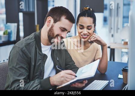 Building on a solid creative strategy. two young designers working together in an office. Stock Photo
