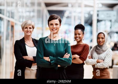 Self-confidence is the foundation of all great success and achievement. Portrait of a young businesswoman standing in an office with her colleagues in Stock Photo