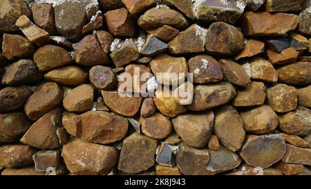 Beautiful background pattern image of a wall made of round stone red color rocks. Landscape abstract texture Stock Photo