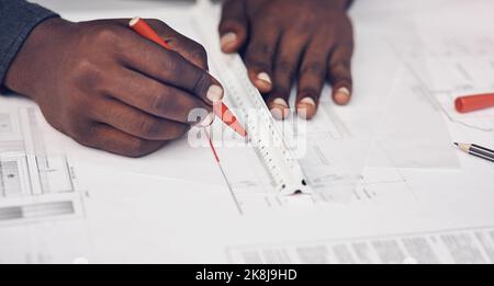 Accuracy is a huge part of his profession. High angle shot of an unrecognizable male architect making some measurements on his blueprints in a modern Stock Photo