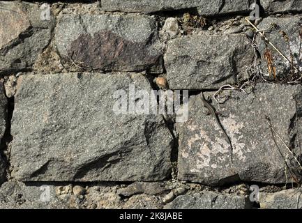 Stone wall with decorative stones and facings Stock Photo