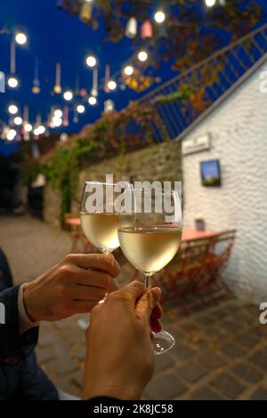 Couple drinking white wine in a restaurant on a romantic streeet with lights in Szentendre Hungary Stock Photo