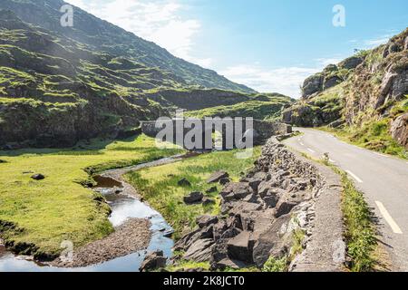 The old Wishing Bridge in green valley, Gap of Dunloe in Black Valley, Ring of Kerry, County Kerry, Ireland Stock Photo