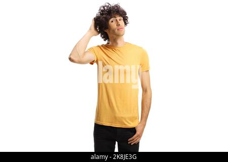 Pensive young man with curly hair thinking and holding head isolated on blue background Stock Photo