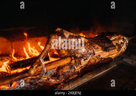 The lamb is cooked entirely on a spit on the fire. Cooking Stock Photo