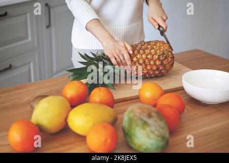 Girl hands cutting fruits on cutting board, close up shot. Healthy eating concept. Raw food Stock Photo