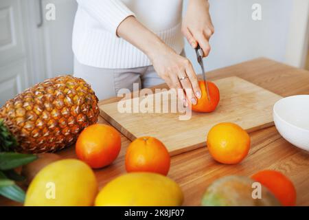 Girl hands cutting fruits on cutting board, close up shot. Healthy eating concept. Raw food Stock Photo