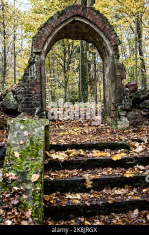 old medieval cemetery gate. Arch shaped building, no fence, entrance in abandoned burial ground made of bricks with staircase Stock Photo