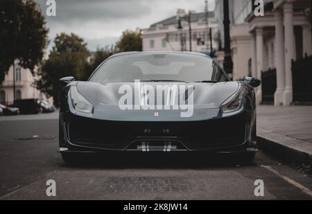 Blue Ferrari 488 pista showing off around London during a moody day. Parked in the richest districts of London. Stock Photo