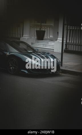 Blue Ferrari 488 pista showing off around London during a moody day. Parked in the richest districts of London. Stock Photo