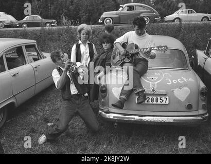 Karlskoga, August 1963, Sweden. 30 - 40,000 young people, including some raggers, take Karlskoga to look at cannon race (car race). Police are meeting strong to keep calm in the city. Youth gathered around a car. Plays guitar Photo: Ivar Aaserud / Current / NTB Stock Photo