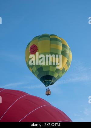 Sint Niklaas, Belgium, September 04, 2022, Beautiful hot air balloon with different colors yellow and green takes off Stock Photo