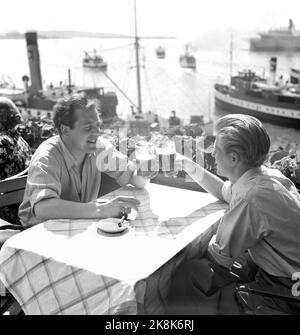 Oslo 19520707. Hot summer in Eastern Norway. Here from outdoor restaurant in Oslo, people enjoy themselves with the heat. Smokes cigarettes. Photo: NTB Archive / NTB Stock Photo