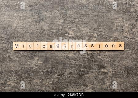 Microaggressions word written on wood block. Microaggressions text on cement table for your desing, concept. Stock Photo