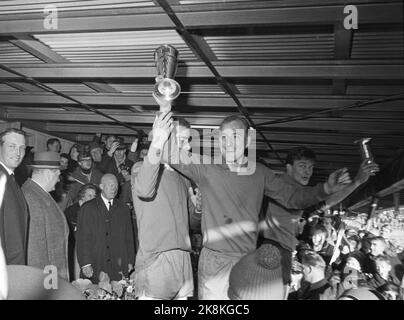 Oslo, 19651107. Ullevaal Stadium. Skeid -frigg 2-1. Cup final in football. This is from the third match. Skeids Finn Thorsen raises the King's Cup. King Olav and Crown Prince Harald are left in the picture. Photo: Henrik Laurvik Stock Photo