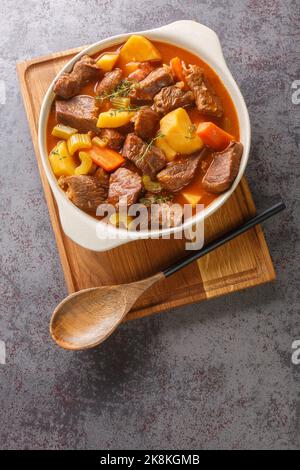 Irish stew stobhach is a stew native to Ireland that is traditionally made with root vegetables and meat closeup in the pot on the table. Vertical top Stock Photo