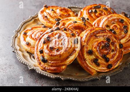French traditional pastries Pains aux raisins closeup in the plate on the table. Horizontal Stock Photo