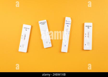 top down view of different positive Covid-19 SARS-CoV-2 rapid tests on vivid orange background Stock Photo