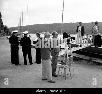 Hankø in the summer of 1956. Recording Norway's first feature film in color, titled 'Smugglers in tuxedo'. Here is a recording, the man with the sunglasses is probably photographer Finn Bergan? (or film photographer and clipper Per G. Jonson/Per Gunnar 'Pege' Jonson). TV. Representatives of the police and customs authorities who have been at their disposal for the film recordings. Photo: Aage Storløkken / Current / NTB. Stock Photo