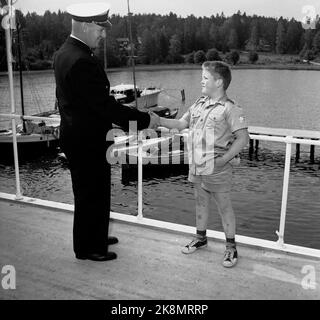 Hankø in the summer of 1956. Recording Norway's first feature film in color, titled 'Smugglers in tuxedo'. Here, the young actor Andreas Diesen greets one of the Customs Service's representatives, who has made available to the filming. Andreas is the son of Ernst Diesen who plays the role of Colonel Lieutenant Brusefjær in the film. Andreas in the role of Lille-Bertram. Photo: Aage Storløkken / Current / NTB. Stock Photo