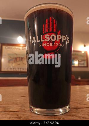 Pint glass in a bar, Allsopps Ales Since 1730, dark beer or stout, red hand logo trademark. Brewery