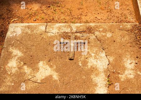 Aparecida de Goiânia, Goias, Brazil – October 23, 2022: A simple cross engraved on the concrete grave in a cemetery. Stock Photo