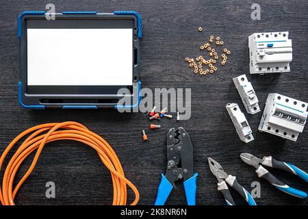 Different electrical tools and digital tablet on wooden background, flat lay. Stock Photo