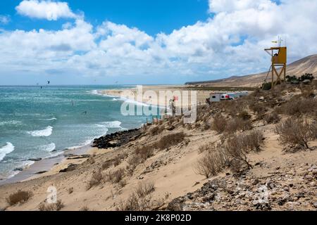 View of beach in Fuerteventura island with windsurfers in blue turquoise water during summer vacation holidays Stock Photo