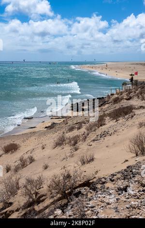 View of beach in Fuerteventura island with windsurfers in blue turquoise water during summer vacation holidays Stock Photo