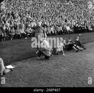 Oslo, 19561021. The cup final at Ullevaal Stadium. Larvik Turn - Skeid 1-2. Skeid supporter and revue artist Einar Rose waves a pennant. Young boys along the sidelines look strange at him. Photo: Current / NTB Stock Photo