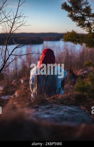 lonely man sitting and looking at sunset behind a river dramatic and loneliness, Stock Photo