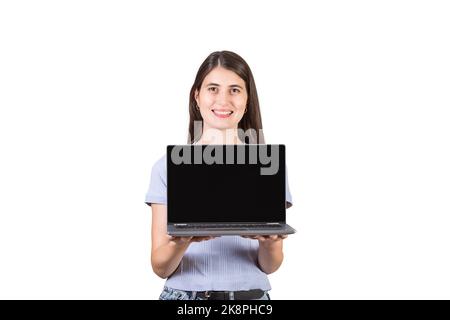 Cheerful young woman holding a laptop in her hands showing the blank screen to camera isolated on white background. PC recommendation, marketing and a Stock Photo
