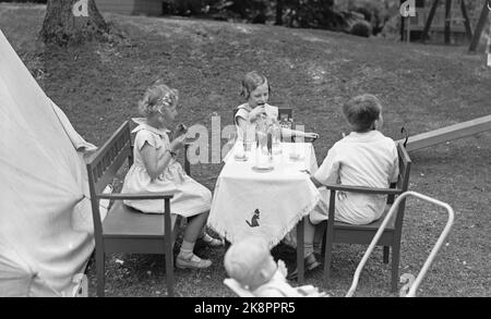 Skaugum June 1937. Princess Ragnhild (th) and Princess Astrid play in the garden at Skaugum, along with an unidentified boy. The three together at a table covered with doll's wise Photo: NTB / NTB Stock Photo