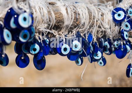 many traditional turkish Evil Eye Bead Amulets on the tree nazar boncuk from blue glass Stock Photo