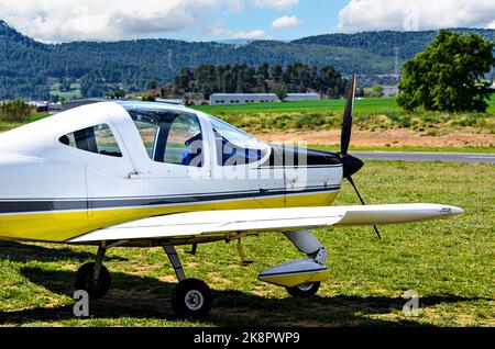 Single engine ultralight airplane waiting to take off at the airfield with blue sky and field background Stock Photo