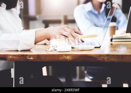 Female Charging Smartphone Using Wireless fast Charging pad at work. Stock Photo