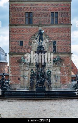 A vertical shot of the Neptune Fountain in front of the Frederiksborg castle in Hilerod, Denmark Stock Photo