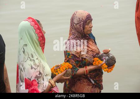 Unidentified Indian men and women pray and devote for Chhath Puja festival on Ganges river side in Varanasi, India. Stock Photo