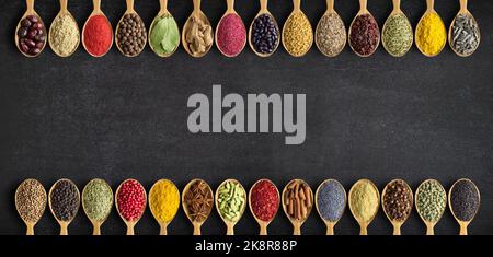 Composition of small spoons full of spices and condiments for cooking on a  black background Stock Photo - Alamy