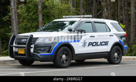 Lincoln City, OR, USA - September 15, 2022; Lincoln City police car parked against woodland Stock Photo