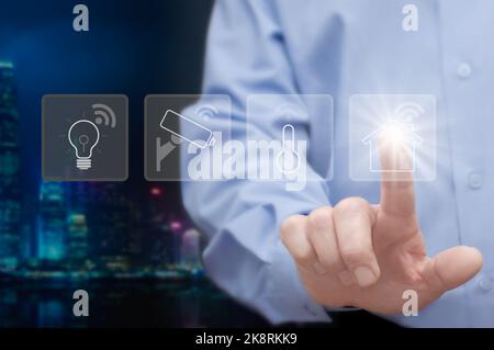 Man touches the icon of smart home service, including security, light, power, climate control, e.t.c. Concept of smart home / smart house. Stock Photo