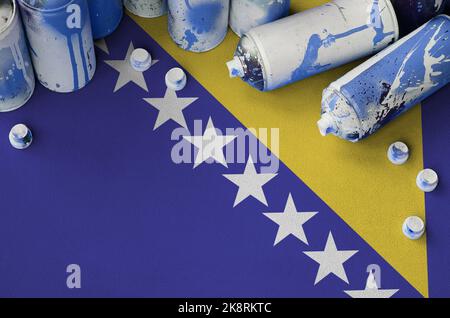 Bosnia and Herzegovina flag and few used aerosol spray cans for graffiti painting. Street art culture concept, vandalism problems Stock Photo