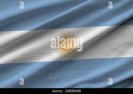 Argentina flag with big folds waving close up under the studio light indoors. The official symbols and colors in fabric banner Stock Photo