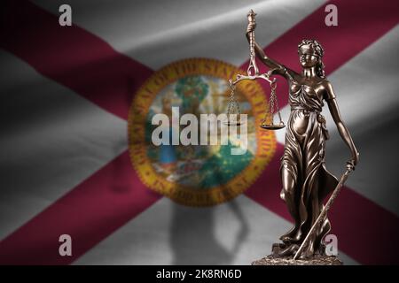 Florida US state flag with statue of lady justice and judicial scales in dark room. Concept of judgement and punishment, background for jury topics Stock Photo