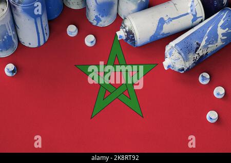 Morocco flag and few used aerosol spray cans for graffiti painting. Street art culture concept, vandalism problems Stock Photo