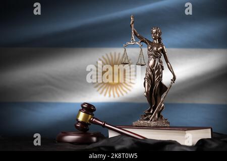 Argentina flag with statue of lady justice, constitution and judge hammer on black drapery. Concept of judgement and punishment Stock Photo